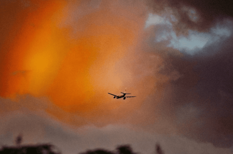 Airplane flying through colorful sky